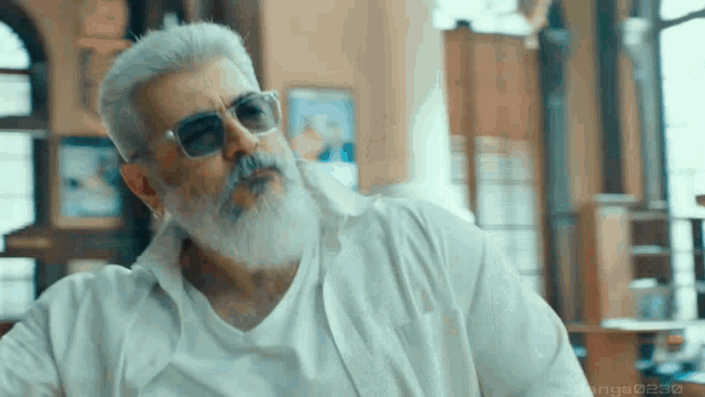 a man with a beard wearing sunglasses and a white shirt has the numbers 0232 on the bottom right