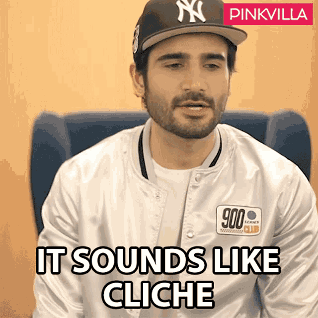 a man wearing a new york yankees hat and a white jacket says it sounds like cliche