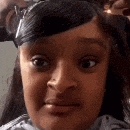 a young girl is making a funny face while getting her hair dyed .