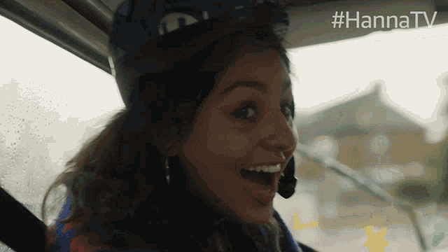 a woman wearing a helmet is sitting in a car with #hannatv written on the bottom