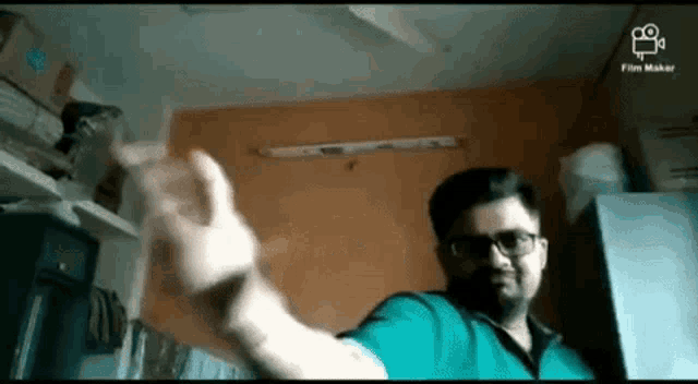 a man wearing glasses is making a funny face while standing in front of an orange wall .