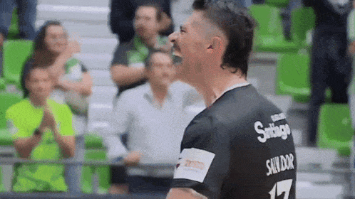 a man wearing a black shirt with the number 17 on it is screaming in a stadium .