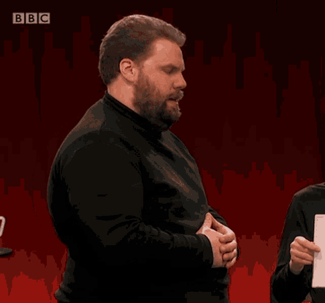 a man with a beard says " medically fascinating " in front of a red background