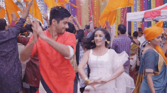 a man and a woman are dancing in front of a crowd