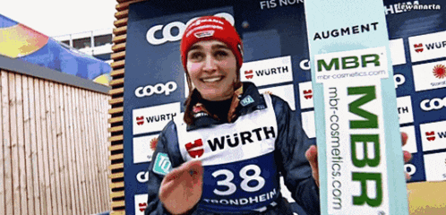 a woman wearing a wurth shirt is holding a sign