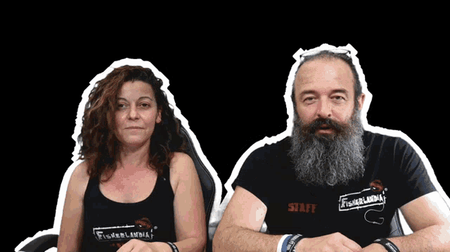 a man and a woman are sitting next to each other with the man wearing a shirt that says staff