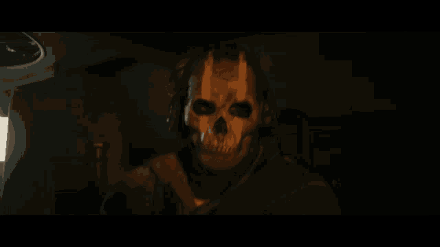 a man wearing a skull mask looks at the camera