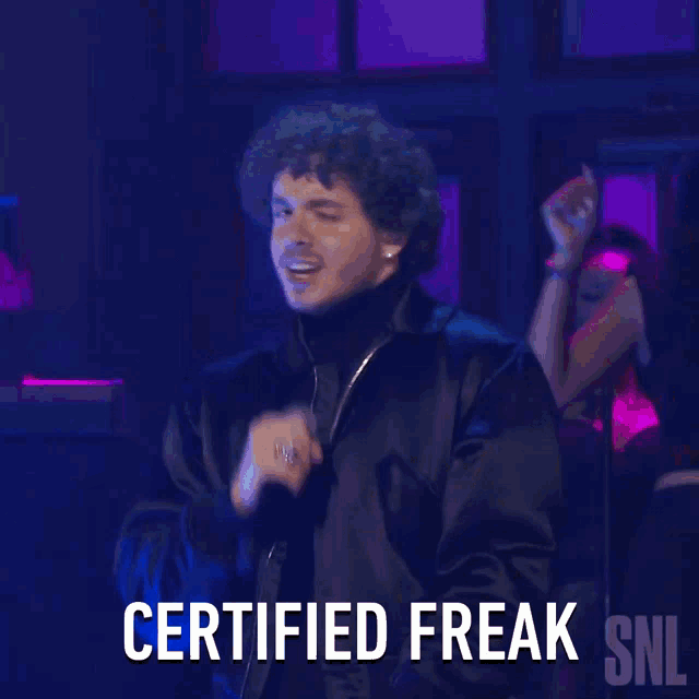 a man singing into a microphone with the words certified freak snl below him