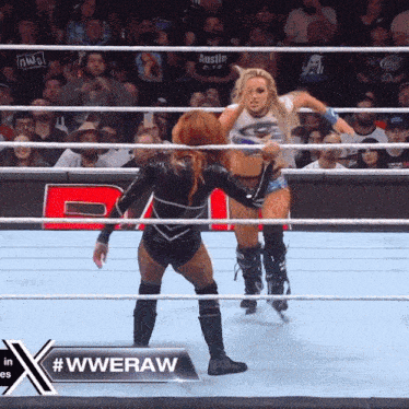 two women in a wrestling ring with a sign that says #wweraw in the corner