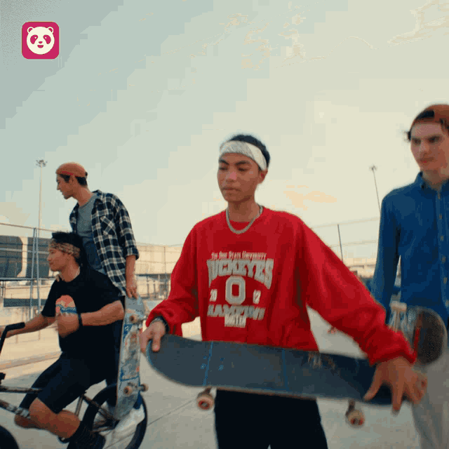 a man wearing a red shirt with the number 0 on it holds a skateboard