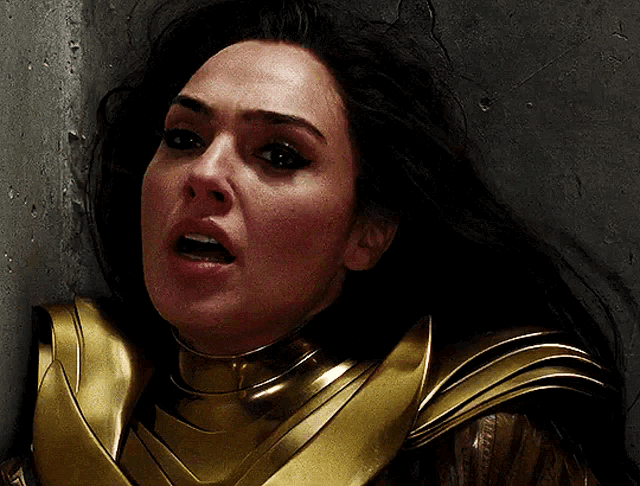 a close up of a woman 's face in a gold armor