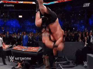 two men are wrestling in a wrestling ring and the words w network are on the bottom of the screen