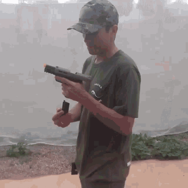 a man is holding a gun and wearing a shirt that says aurora