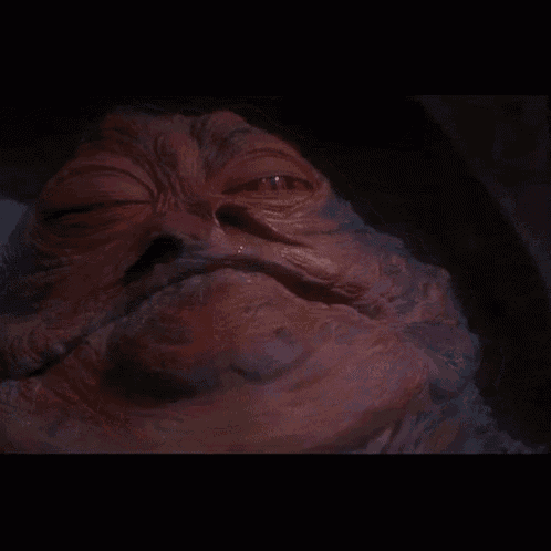 a close up of the face of jabba the hutt
