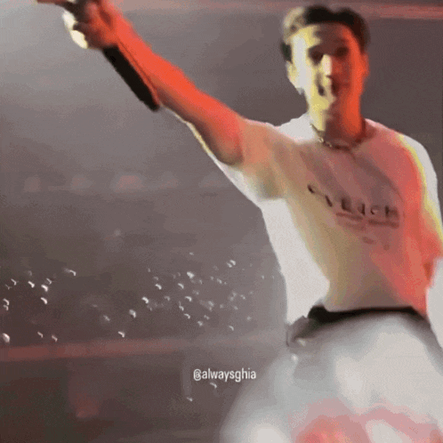 a man in a white shirt is holding a microphone in his hand