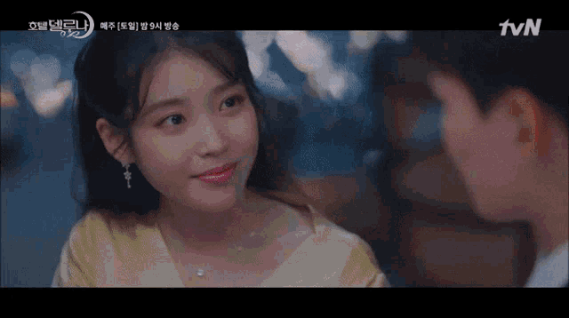 a woman in a yellow top is looking at a man in a tvn advertisement