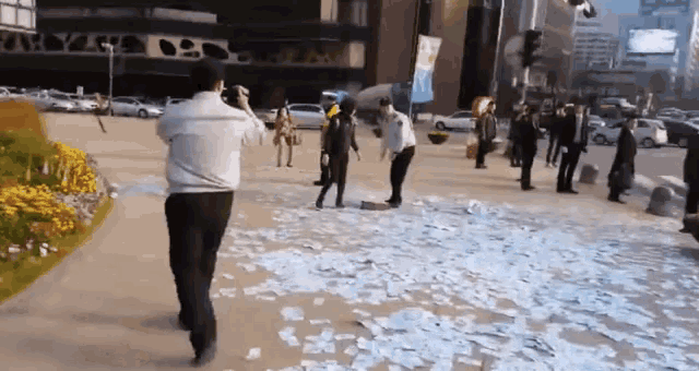 a man taking a picture of a group of people standing on a sidewalk