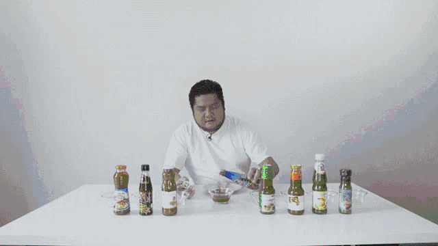 a man is sitting at a table with bottles of sauce and a sign that says otsuki