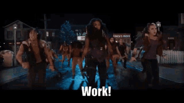 a group of people are walking down a street and the word work is on the screen