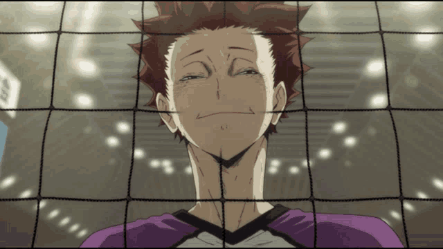 a man with a purple shirt is behind a volleyball net