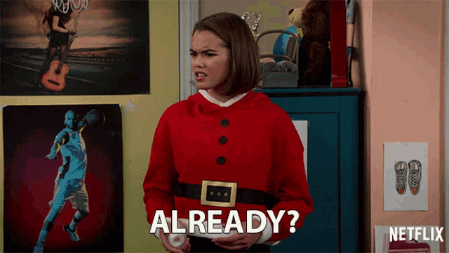 a girl in a santa suit says already in front of a netflix sign