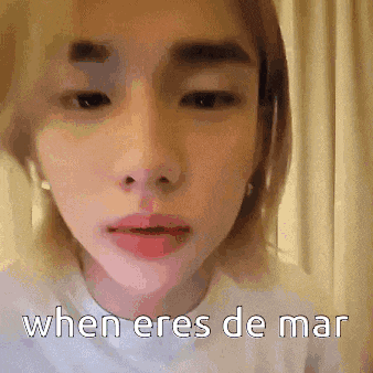 a close up of a person 's face with the words `` when eres de mar '' written on the bottom .