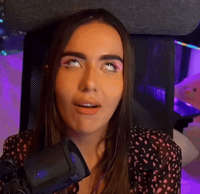 a woman is sitting in front of a microphone and making a face .