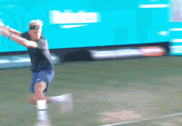 a man is swinging a tennis racket on a court