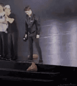 a group of people are standing on a stage with a microphone .
