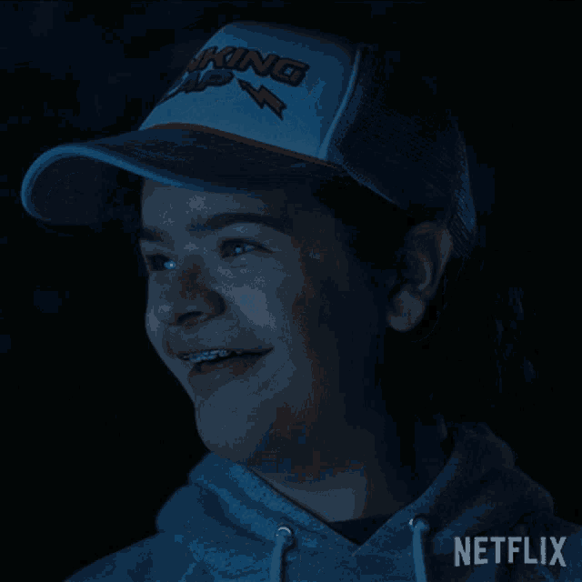 a person wearing a netflix hoodie and a trucker hat
