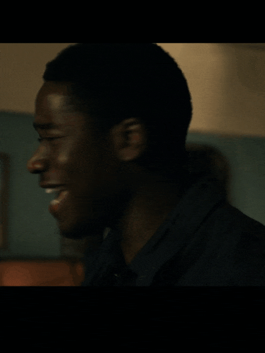 a man is smiling in front of a dart board in a dark room