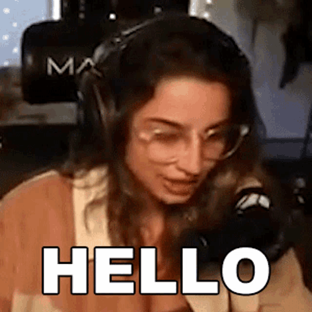 a woman is wearing headphones and glasses and says hello
