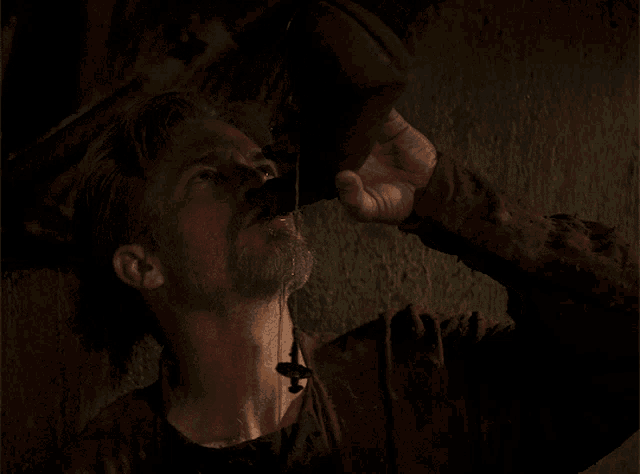 a man with a beard drinks from a bottle