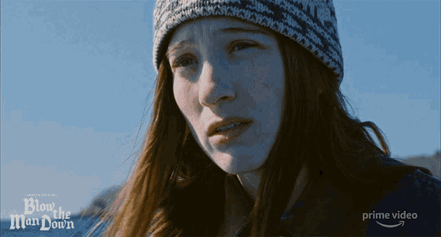 a woman wearing a knitted hat with the words blow the man down behind her