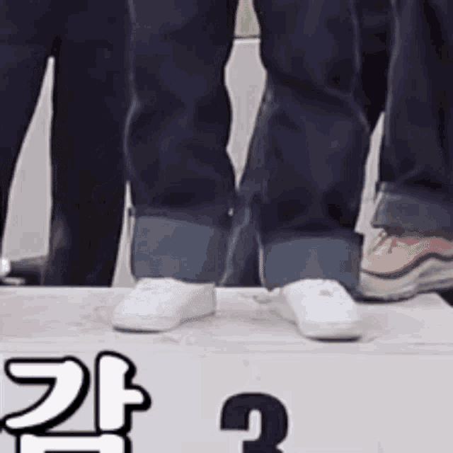 a close up of a person 's feet wearing white sneakers standing on a podium .