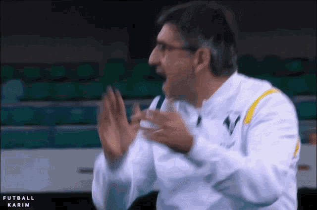 a man in a white and yellow jacket with the word karim on the bottom right