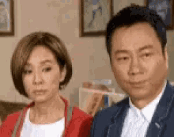 a man and a woman are sitting next to each other in a room .