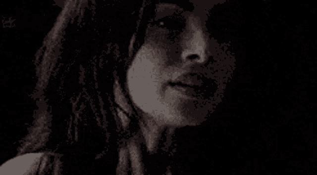 a close up of a woman 's face in a black and white photo with her eyes closed .