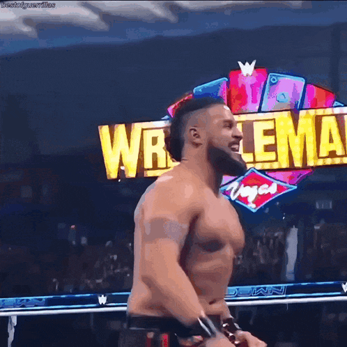 a man without a shirt is standing in front of a sign that says wrestlemania vegas