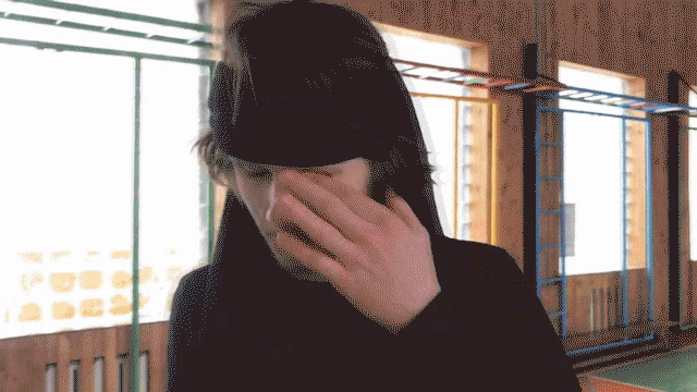 a man wearing a black headband is covering his nose