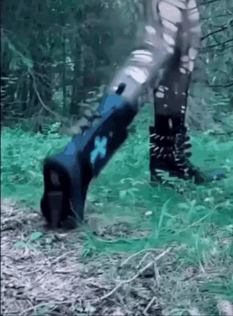 a person wearing blue boots is walking through a forest .