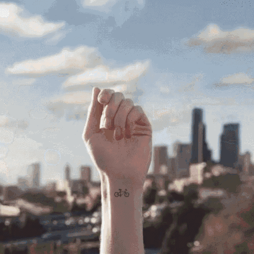 a person has a small tattoo on their wrist of a bike