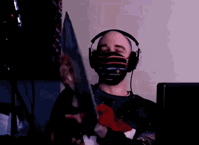 a man wearing a mask and headphones holds a piece of paper in his hand