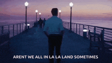 a man is standing on a pier with his hands in his pockets and a quote from the movie la la land .
