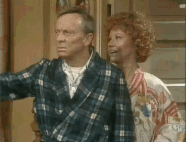 a man and woman are standing next to each other in a room .