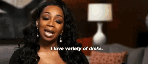 a woman is sitting on a couch with her mouth open and says `` i love variety of dicks '' .