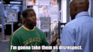 a man wearing a jamaican shirt is talking to another man in a store .