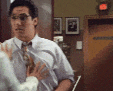 a man in a white shirt and tie is talking to a woman in front of a door that says ' closed ' on it