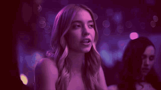 a woman in a purple dress is looking up at something