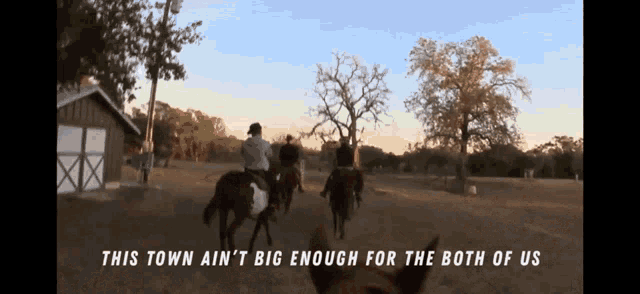 a group of people riding horses with the words " this town ain 't big enough for the both of us "